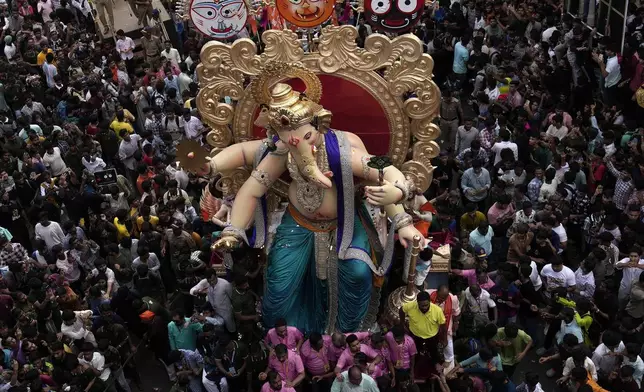 People carry idol of elephant-headed Hindu god Ganesh from the workshop to pandal, a temporary shelter, ahead of the Ganesh Chaturthi festival in Mumbai, India, Saturday, Aug. 31, 2024. (AP Photo/Rajanish Kakade)