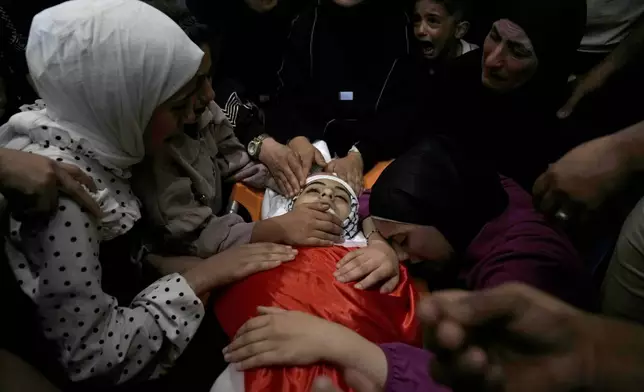 Mourners take the last look at the body of Palestinian girl Bana Bakr, 13, at the family house during her funeral in the West Bank village of Qaryut, south of Nablus, Saturday, Sept. 7, 2024. Bakr was killed by Israeli fire, the Palestinian health ministry said. The Israeli army said they were reviewing the incident. (AP Photo/Nasser Nasser)