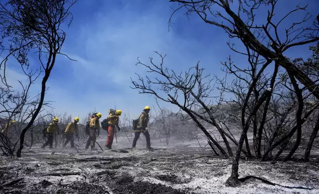 Members of Riverside County Cal Fire monitor for hot spots while battling the Airport Fire Wednesday, Sept. 11, 2024, in El Cariso Village, in unincorporated Riverside, County, Calif. (AP Photo/Gregory Bull)