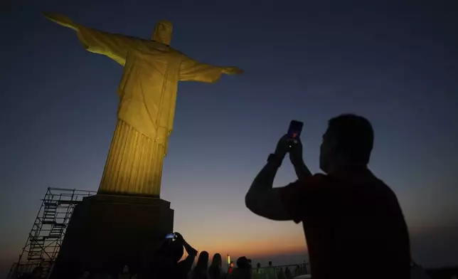 A tourist takes a photo of the Christ the Redeemer statue in Rio de Janeiro, Tuesday, Sept. 10, 2024. (AP Photo/Hannah-Kathryn Valles)