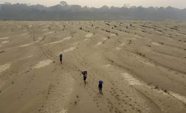 Residents transport drinking water from Humaita to the Paraizinho community, along the dry Madeira River, a tributary of the Amazon River, during the dry season, Amazonas state, Brazil, Sunday, Sept. 8, 2024. (AP Photo/Edmar Barros)