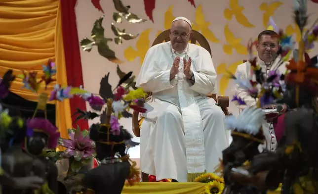 Pope Francis, left, attends a traditional dance performed by the Caritas Technical Secondary School pupils in Port Moresby, Saturday, Sept. 7, 2024. (AP Photo/Gregorio Borgia)