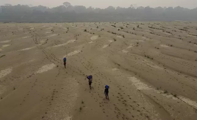 Residents transport drinking water from Humaita to the Paraizinho community, along the dry Madeira River, a tributary of the Amazon River, during the dry season, Amazonas state, Brazil, Sunday, Sept. 8, 2024. (AP Photo/Edmar Barros)