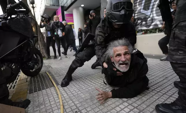 Police detain a protestor during a demonstration against President Javier Milei's veto of a pension raise in front of Congress in Buenos Aires, Argentina, Wednesday, Sept. 11, 2024. (AP Photo/Rodrigo Abd)