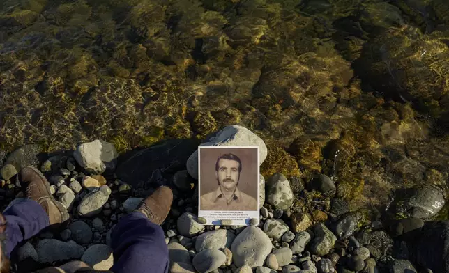 Juan Carlos Chavez stands near a picture of his father Ismael Chavez who went missing during the Pinochet dictatorship, during a ceremony in Villa Baviera formerly known as Colonia Dignidad that was used as a torture center, to mark the anniversary of the coup against Salvador Allende's government in 1973, near Parral, Chile, Saturday, Sept. 7, 2024. (AP Photo/Esteban Felix)