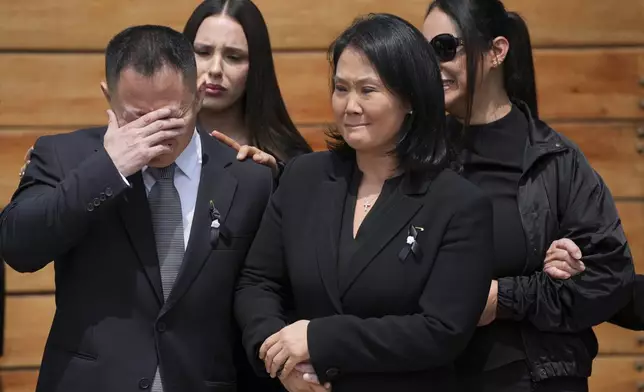 Keiko Fujimori, right, and her brother Kenji stand by as pallbearers carry the coffin of their father, former President Alberto Fujimori, out of Keiko's home the day after he died in Lima, Peru, Thursday, Sept. 12, 2024. (AP Photo/Guadalupe Pardo)