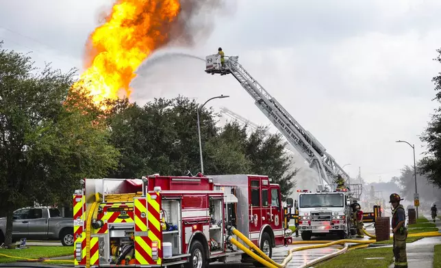 Firefighters protect a neighborhood from a fire in a pipeline carrying liquified natural gas burns near Spencer Highway and Summerton on Monday, Sept. 16, 2024, in La Porte, Texas. (Brett Coomer/Houston Chronicle via AP)