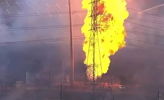 A burned vehicle sits near a pipeline fire in La Porte, Texas, Monday, Sept. 16, 2024. (KTRK via AP)