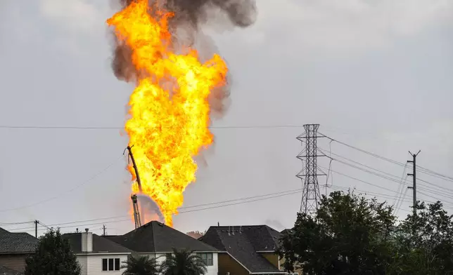 A firefighter directs a line of water around a fire on a pipeline carrying liquified natural gas near Spencer Highway and Summerton on Monday, Sept. 16, 2024, in La Porte, Texas. (Brett Coomer/Houston Chronicle via AP)