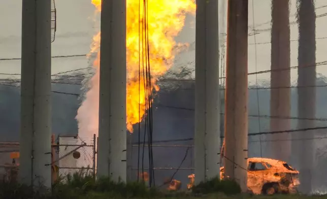 A massive pipeline fire burns after a vehicle drove through a fence along a parking lot and struck an above-ground valve near Spencer Highway and Summerton on Monday, Sept. 16, 2024, in La Porte, Texas. (Brett Coomer/Houston Chronicle via AP)