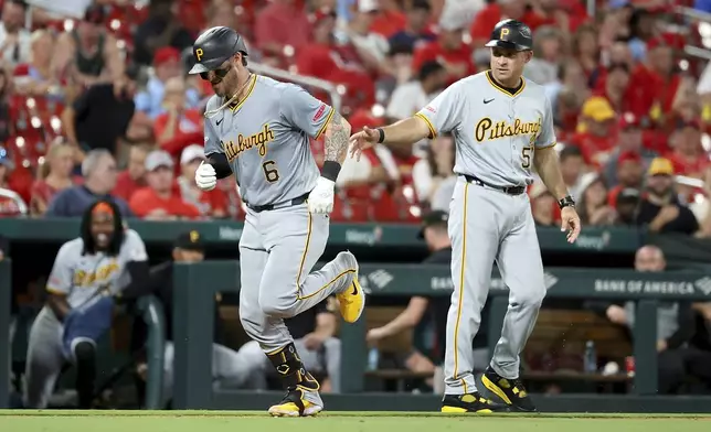 Pittsburgh Pirates' Yasmani Grandal, left, is congratulated by third base coach Mike Rabelo, right, as he runs the bases after hitting a solo home run during the seventh inning against the St. Louis Cardinals, Thursday, Sept. 19, 2024, in St. Louis. (AP Photo/Scott Kane)