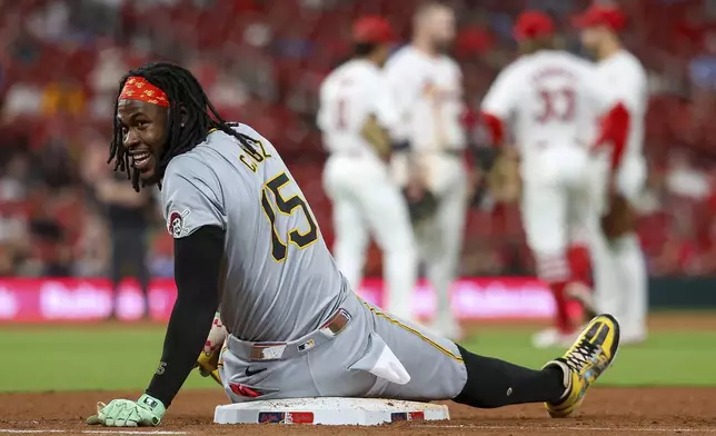 Pittsburgh Pirates' Oneil Cruz sits on first base as he waits for a St. Louis Cardinals pitching change to be completed during the eighth inning of a baseball game Thursday, Sept. 19, 2024, in St. Louis. (AP Photo/Scott Kane)