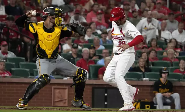 St. Louis Cardinals' Nolan Arenado, right, scores past Pittsburgh Pirates catcher Yasmani Grandal during the eighth inning of a baseball game Monday, Sept. 16, 2024, in St. Louis. (AP Photo/Jeff Roberson)