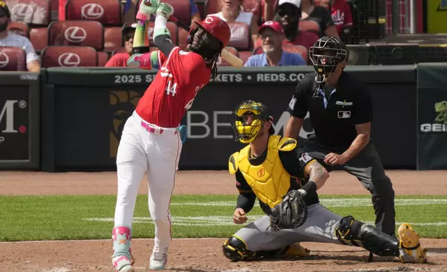 Cincinnati Reds' Elly De La Cruz watches his three-run homer with Pittsburgh Pirates catcher Yasmani Grandal (6) and home plate umpire Charlie Ramos during the fourth inning of a baseball game, Saturday, Sept. 21, 2024, in Cincinnati. (AP Photo/Carolyn Kaster)