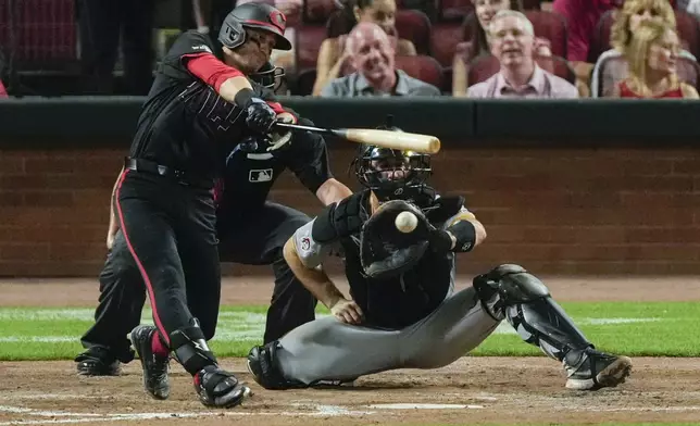 Cincinnati Reds' TJ Friedl, front left, hits an RBI single as Pittsburgh Pirates catcher Joey Bart, right, looks on during the fourth inning of a baseball game, Friday, Sept. 20, 2024, in Cincinnati. (AP Photo/Carolyn Kaster)