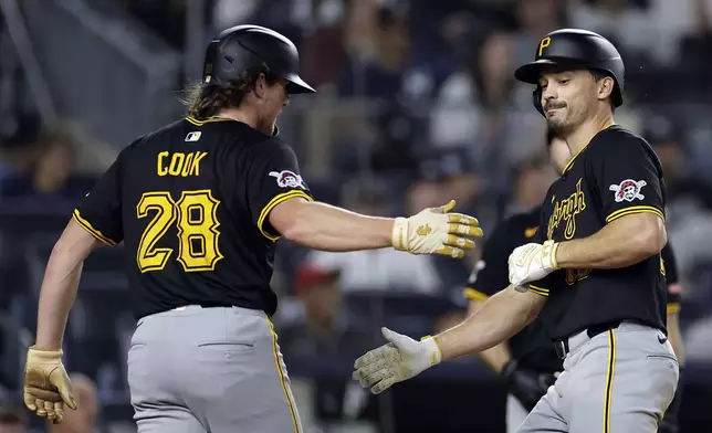 Pittsburgh Pirates' Bryan Reynolds, right, is greeted Billy Cook (28) after hitting a two-run home run during the eighth inning of a baseball game against the New York Yankees, Friday, Sept. 27, 2024, in New York. (AP Photo/Adam Hunger)