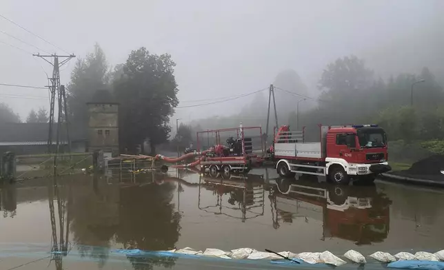 This handout photo provided by the Polish fire department, shows firefighters pump water and mud from city streets and help clean the city of Głogow that was hit by a high flood wave, in Głogow, southwestern Poland, on Wednesday, Sept. 18, 2024. (KG PSP via AP)