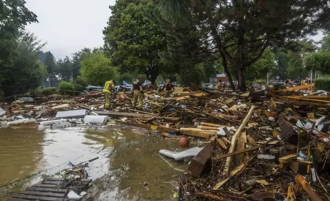 This handout photo provided by the Polish fire department, shows firefighters removing piles of debris dumped in the streets by high flood wave that is passing through southwestern Poland, in Glucholazy, Poland, on Tuesday, Sept. 17, 2024. ( Marcin Muskala/KG PSP via AP)