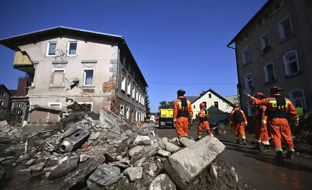 On this handout photo provided by the State Fire Service of Poland, firefighters inspecting safety of houses following heavy flooding in the town of Stronie Slaskie, southwestern Poland, Wednesday, Sept. 18, 2024. (Tomasz Fijołek/KG PSP via AP)