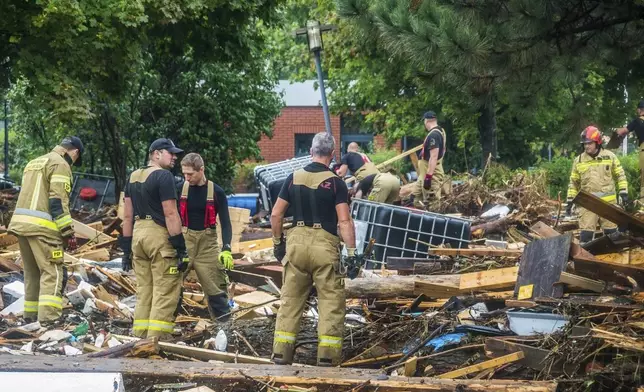 This handout photo provided by the Polish fire department, shows firefighters removing piles of debris dumped in the streets by high flood wave that is passing through southwestern Poland, in Glucholazy, Poland, on Tuesday, Sept. 17, 2024. ( Marcin Muskala/KG PSP via AP)