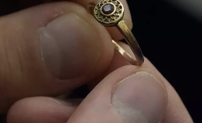 A relative shows a golden ring that was confiscated by Nazi Germans from Zofia Strusińska , who was captured by Nazi troops during Warsaw Uprising in 1944 and taken to a forced labor camp. Her seized items that had been stored at Germany's Arolsen Archives, were returned to Strusińska's relatives in a ceremony in Warsaw, Poland, on Tuesday, Sept. 10, 2024, in which 10 other families also had belongings of their relatives returned.(AP Photo/Czarek Sokolowski)