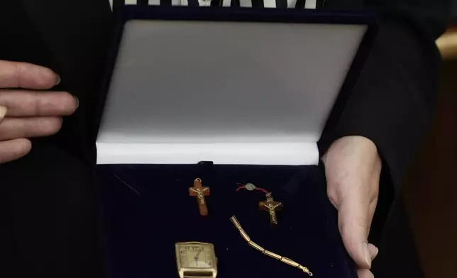 A relative shows amber crucifixes and jewelry that were confiscated by Nazi Germans from Stanislawa Wasilewska, who was captured by Nazi troops during Warsaw Uprising in 1944 and taken to a forced labor camp. The items that had been stored at Germany's Arolsen Archives, were returned to Wasilewska's relatives in a ceremony in Warsaw, Poland, on Tuesday, Sept. 10, 2024, in which 10 other families also had belongings of their relatives returned. (AP Photo/Czarek Sokolowski)