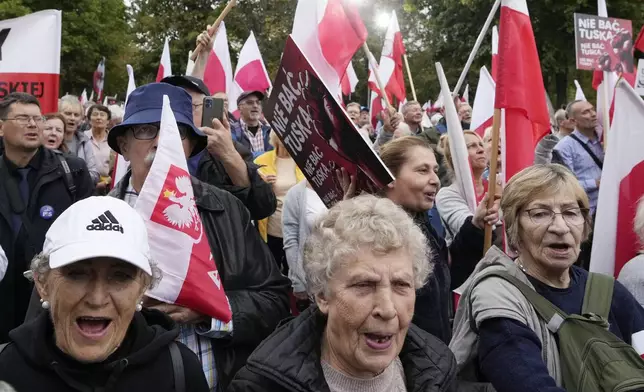 Backers of the right-wing opposition party Law and Justice take part in a protest ally of a few thousand people against the policies of Prime Minister Donald Tusk's Cabinet in Warsaw, Poland, Saturday Sept. 14, 2024. (AP Photo/Czarek Sokolowski)