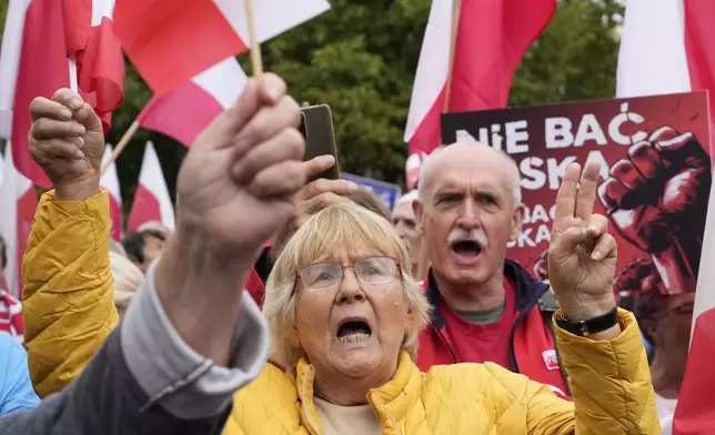 Backers of the right-wing opposition party Law and Justice take part in a protest ally of a few thousand people against the policies of Prime Minister Donald Tusk's Cabinet before the Ministry of Justice, in Warsaw, Poland, Saturday Sept. 14, 2024. (AP Photo/Czarek Sokolowski)