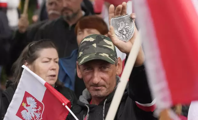 Backers of the right-wing opposition party Law and Justice take part in a protest ally of a few thousand people against the policies of Prime Minister Donald Tusk's Cabinet in Warsaw, Poland, Saturday Sept. 14, 2024. (AP Photo/Czarek Sokolowski)