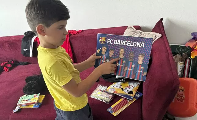 Sava Trypolsky, a 7-year-old boy from Ukraine, looks at a picture depicting Barcelona soccer players, in his room in Jablonna, Poland, Friday, Aug. 30, 2024. (AP Photo/Vanessa Gera)