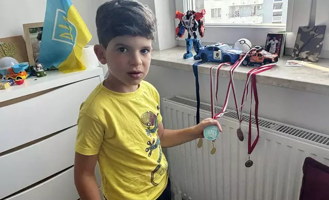 Sava Trypolsky, a 7-year-old boy from Ukraine, shows off soccer medals in his room in Jablonna, Poland, Friday Aug. 30, 2024. (AP Photo/Vanessa Gera)