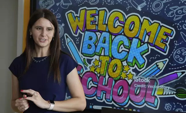 Yana Kudina, a Ukrainian teacher who gives Polish language to Ukrainian refugee students, greets her class on the first day of school in Warsaw, Poland, Monday Sept. 2, 2024. (AP Photo/Vanessa Gera)