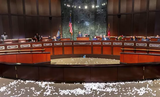 Ping pong balls litter the floor after opponents of the under-construction law enforcement training center known to some as Cop City disrupted the City Council meeting at City Hall in Atlanta on Monday, Sept. 16, 2024. (Arvin Temkar/Atlanta Journal-Constitution via AP)