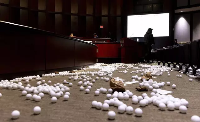 Ping pong balls litter the floor after opponents of the under-construction law enforcement training center known to some as Cop City disrupted the City Council meeting at City Hall in Atlanta on Monday, Sept. 16, 2024. (Arvin Temkar/Atlanta Journal-Constitution via AP)