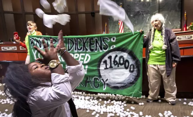 Ping pong balls litter the floor after opponents of the under-construction law enforcement training center known to some as Cop City disrupted the City Council meeting at City Hall in Atlanta on Monday, Sept. 16, 2024. (Arvin Temkar/Atlanta Journal-Constitution via AP)