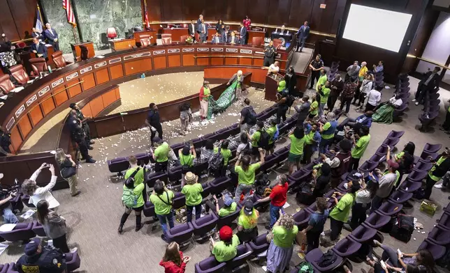 Opponents of the under-construction law enforcement training center known to some as "Cop City" disrupt the City Council meeting at City Hall in Atlanta, Monday, Sept. 16, 2024. (Arvin Temkar/Atlanta Journal-Constitution via AP)