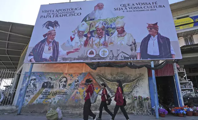 FILE - A billboard welcoming Pope Francis stands above a mural honoring Bishop Belo and three others as national heroes in Dili, East Timor, Aug. 14, 2024. (AP Photo/Achmad Ibrahim, File)