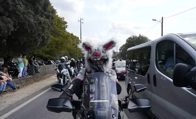 A motorcyclist wearing a furry helmet leaves after attending the IX Pilgrimage of the Blessing of Helmets at the Roman Catholic holy shrine of Fatima, in Fatima, Portugal, Sunday, Sept. 22, 2024. (AP Photo/Ana Brigida)