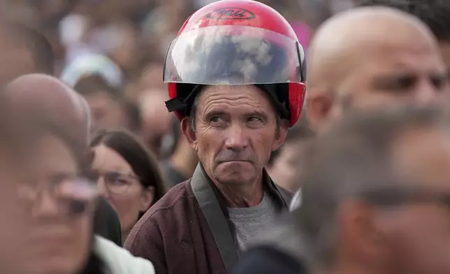 A man attends the IX Pilgrimage of the Blessing of Helmets that draws tens of thousands at the Roman Catholic holy shrine of Fatima, in Fatima, Portugal, Sunday, Sept. 22, 2024. (AP Photo/Ana Brigida)