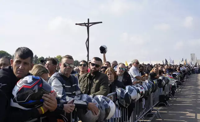 Motorcyclists holding their helmets gather at the Roman Catholic holy shrine of Fatima to attend the IX Pilgrimage of the Blessing of Helmets that draws tens of thousands, in Fatima, Portugal, Sunday, Sept. 22, 2024. (AP Photo/Ana Brigida)