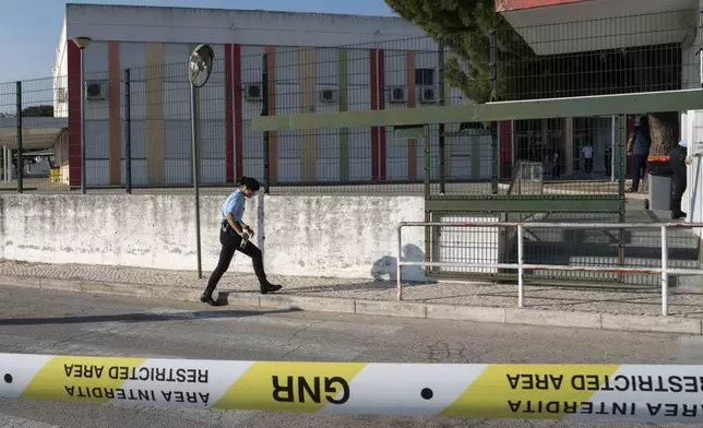 Police officers cordon off the area outside a school following a stabbing attack in Azambuja near Lisbon, Tuesday, Sept. 17, 2024. (AP Photo/Ana Brigida)