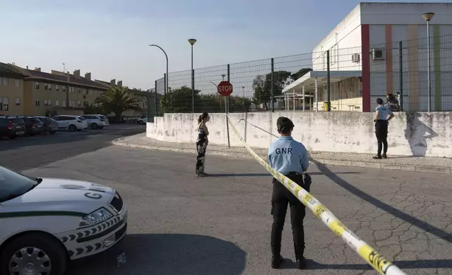 Police officers cordon off the area outside a school following a stabbing attack in Azambuja near Lisbon, Tuesday, Sept. 17, 2024. (AP Photo/Ana Brigida)