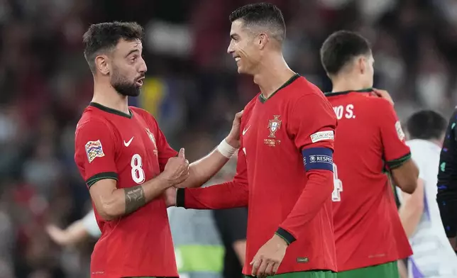 Portugal's Cristiano Ronaldo, centre, celebrates with Bruno Fernandes after the UEFA Nations League soccer match between Portugal and Scotland at the Luz stadium in Lisbon, Portugal, Sunday, Sept. 8, 2024. (AP Photo/Armando Franca)