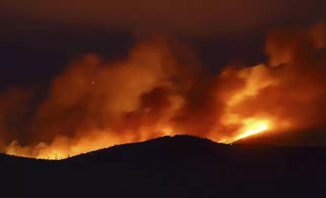 Clouds of smoke drift with the strong wind as fires rage on the hills around Sever do Vouga, a town in northern Portugal that has been surrounded by forest fires, Tuesday, Sept. 17, 2024. (AP Photo/Bruno Fonseca)