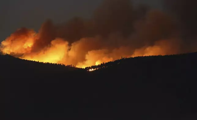 A fire rages on the hills around Sever do Vouga, a town in northern Portugal that has been surrounded by forest fires, Tuesday night, Sept. 17, 2024. (AP Photo/Bruno Fonseca)