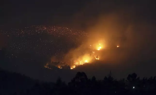 A fire burns on a hillside near Sever do Vouga, a town in northern Portugal that has been surrounded by forest fires, Tuesday, Sept. 17, 2024. (AP Photo/Bruno Fonseca)