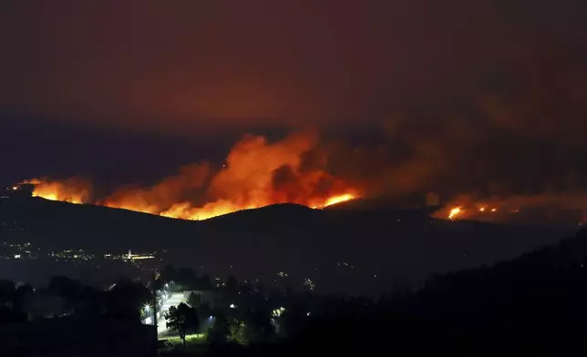 Fires rage on the hills around Sever do Vouga, a town in northern Portugal that has been surrounded by forest fires, Tuesday night, Sept. 17, 2024. (AP Photo/Bruno Fonseca)