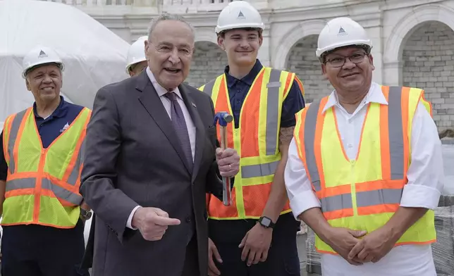 Senate Majority Leader Chuck Schumer, D-N.Y., poses for a photo to the First Nail Ceremony marking the beginning of construction of the 2025 Presidential Inauguration platform, on the steps of the Capitol, Wednesday, Sept. 18, 2024, in Washington. (AP Photo/Mariam Zuhaib)