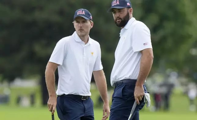 United States team members Scottie Scheffler, right, and Russell Henley line up a putt on the second hole during a first round four-ball match at the Presidents Cup golf tournament at the Royal Montreal Golf Club in Montreal, Thursday, Sept. 26, 2024. (Frank Gunn/The Canadian Press via AP)