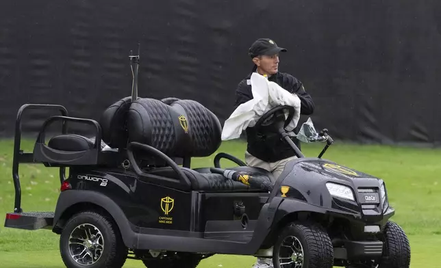 International team captain Mike Weir wipes rain from his golf cart as he attends practice at the Presidents Cup golf tournament at the Presidents Cup golf tournament, Monday, Sept. 23, 2024, in Montreal. (Christinne Muschi/The Canadian Press via AP)